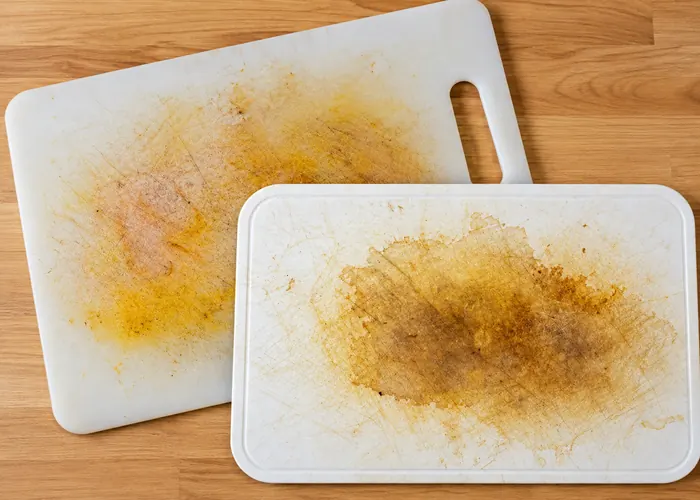 Two stained, scratched plastic cutting boards